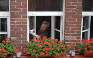 窓を掃除する老婆