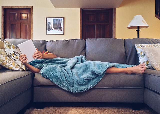 布製のソファーで寝る人