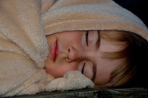ふわふわの毛布で寝る子供