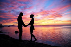 夕方の海辺の夫婦